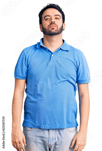 Wallpaper Mural Young hispanic man wearing casual clothes relaxed with serious expression on face. simple and natural looking at the camera. Torontodigital.ca