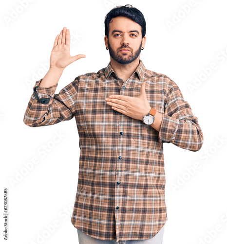 Young hispanic man wearing casual clothes swearing with hand on chest and open palm, making a loyalty promise oath © Krakenimages.com