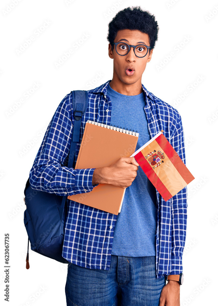 Young african american man wearing student backpack holding spanish flag scared and amazed with open mouth for surprise, disbelief face Young african american man wearing student backpack holding spanish flag scared and amazed with open mouth for surprise, disbelief face