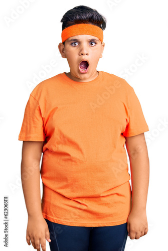 Little boy kid wearing sportswear afraid and shocked with surprise and amazed expression, fear and excited face.