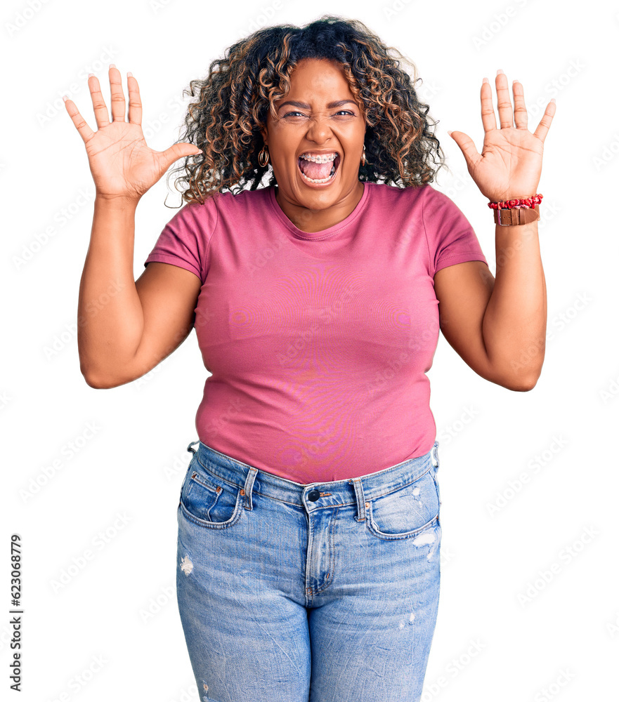 Young african american plus size woman wearing casual clothes celebrating crazy and amazed for success with arms raised and open eyes screaming excited. winner concept Young african american plus size woman wearing casual clothes celebrating crazy and amazed for success with arms raised and open eyes screaming excited. winner concept