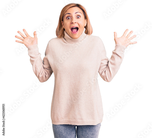 Young blonde woman wearing casual clothes celebrating victory with happy smile and winner expression with raised hands