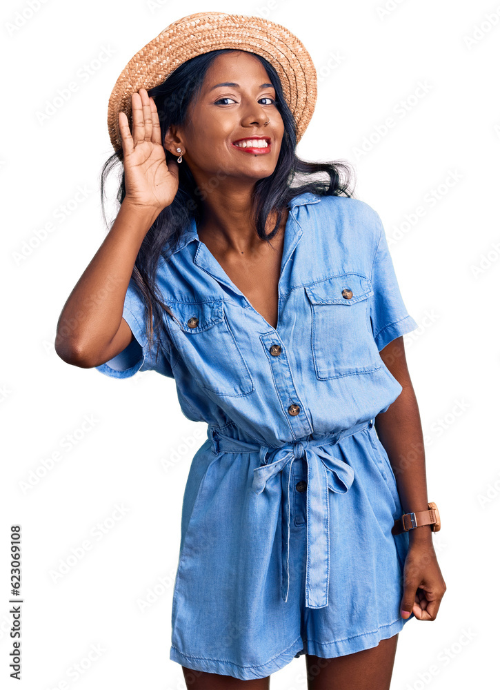 Young indian girl wearing summer hat smiling with hand over ear listening an hearing to rumor or gossip. deafness concept. Young indian girl wearing summer hat smiling with hand over ear listening an hearing to rumor or gossip. deafness concept.