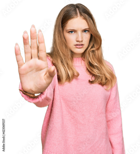 Beautiful young caucasian girl wearing casual winter sweater doing stop sing with palm of the hand. warning expression with negative and serious gesture on the face.