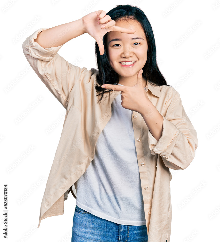 Young chinese woman wearing casual white t shirt and jacket smiling making frame with hands and fingers with happy face. creativity and photography concept. Young chinese woman wearing casual white t shirt and jacket smiling making frame with hands and fingers with happy face. creativity and photography concept.