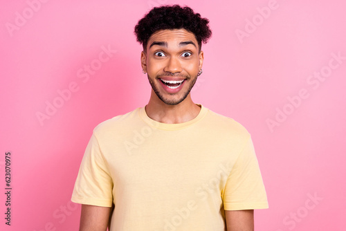 Photo of young hipster dude multinational student open mouth overjoyed wear summer yellow shirt isolated pink color background © deagreez