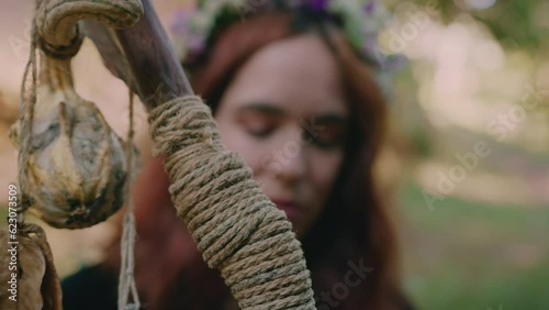 young girl holding her druidic staff in a forest close shot photo