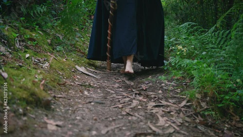 young druid girl walking in a forest feet detail dolly long shot photo