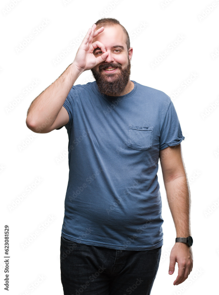 Young caucasian hipster man over isolated background doing ok gesture with hand smiling, eye looking through fingers with happy face. Young caucasian hipster man over isolated background doing ok gesture with hand smiling, eye looking through fingers with happy face.