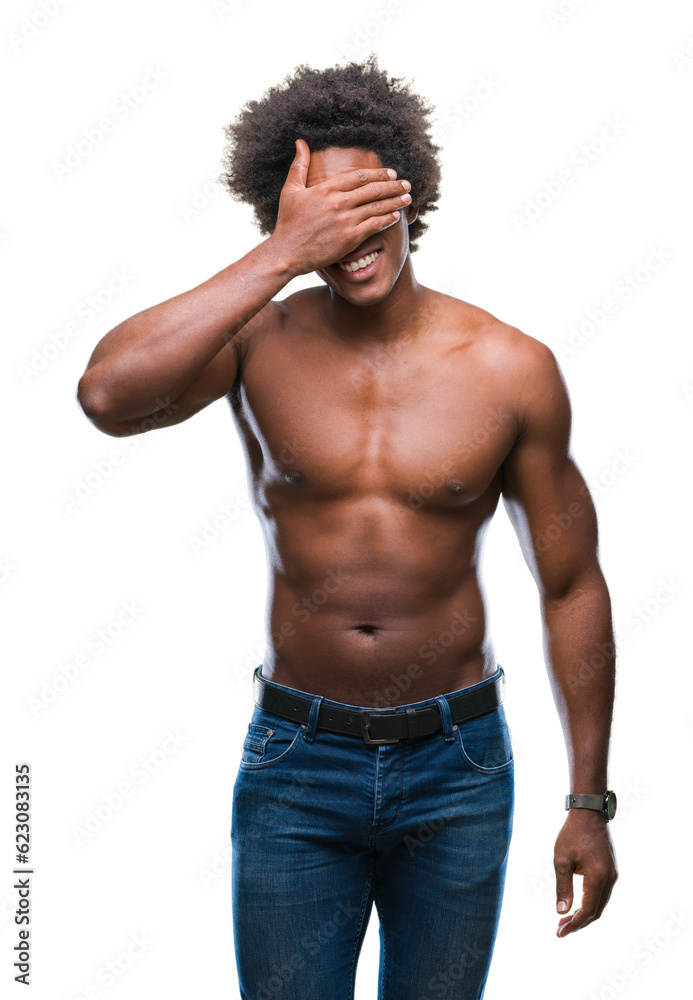 Afro american shirtless man showing nude body over isolated background smiling and laughing with hand on face covering eyes for surprise. Blind concept. Afro american shirtless man showing nude body over isolated background smiling and laughing with hand on face covering eyes for surprise. Blind concept.