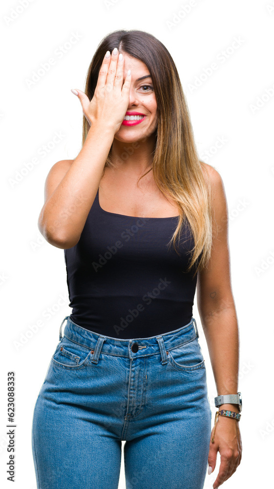 Young beautiful woman over isolated background covering one eye with hand with confident smile on face and surprise emotion. Young beautiful woman over isolated background covering one eye with hand with confident smile on face and surprise emotion.