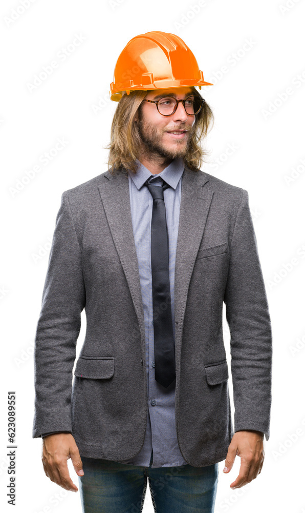 Young handsome architec man with long hair wearing safety helmet over isolated background smiling looking side and staring away thinking. Young handsome architec man with long hair wearing safety helmet over isolated background smiling looking side and staring away thinking.