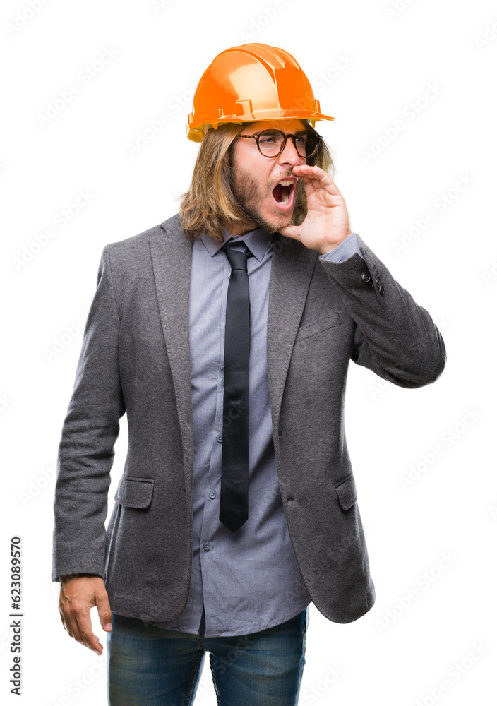 Young handsome architec man with long hair wearing safety helmet over isolated background shouting and screaming loud to side with hand on mouth. Communication concept. Young handsome architec man with long hair wearing safety helmet over isolated background shouting and screaming loud to side with hand on mouth. Communication concept.