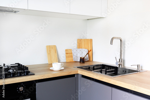Modern luxury loft studio apartment interior with dark grey kitchen, white and wood material. real new interior design