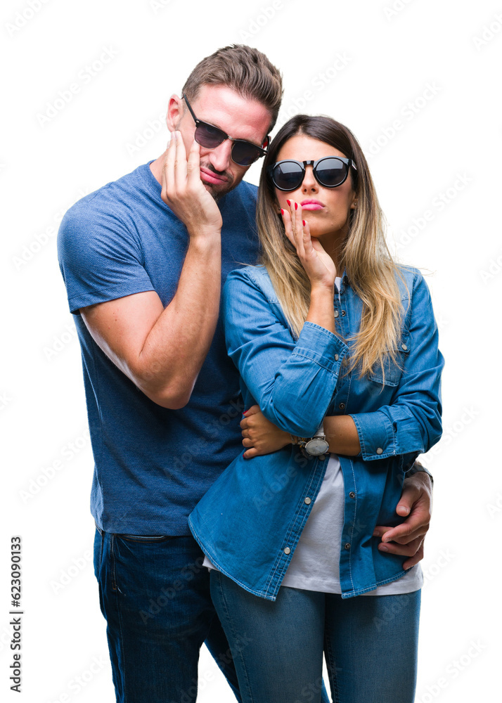Young couple in love wearing sunglasses over isolated background thinking looking tired and bored with depression problems with crossed arms.