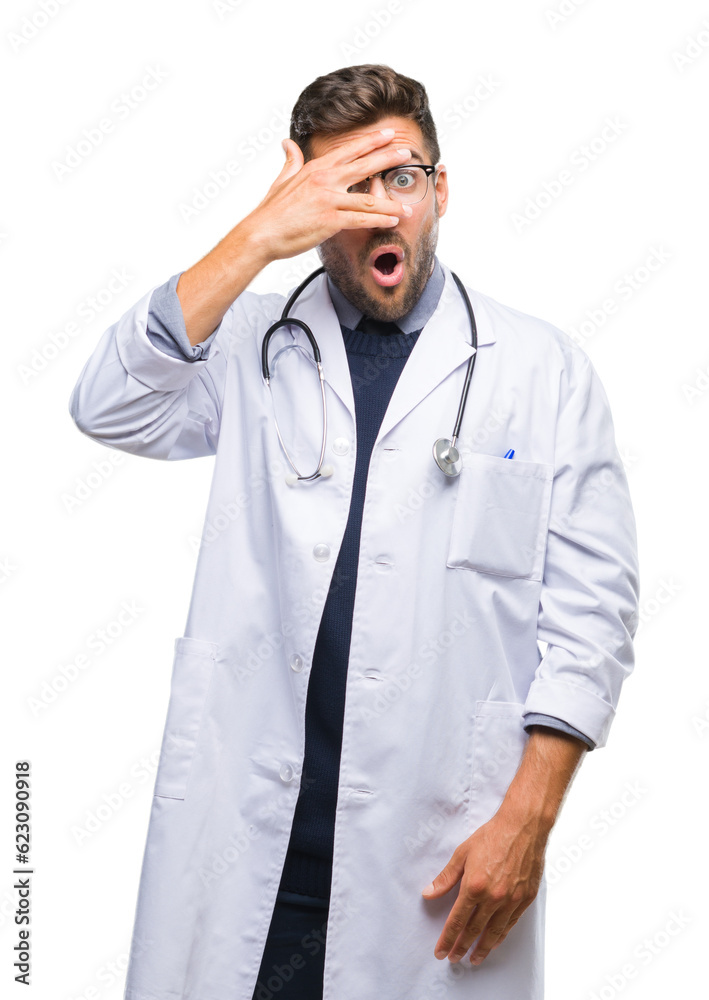 Young handsome doctor man over isolated background peeking in shock covering face and eyes with hand, looking through fingers with embarrassed expression. Young handsome doctor man over isolated background peeking in shock covering face and eyes with hand, looking through fingers with embarrassed expression.