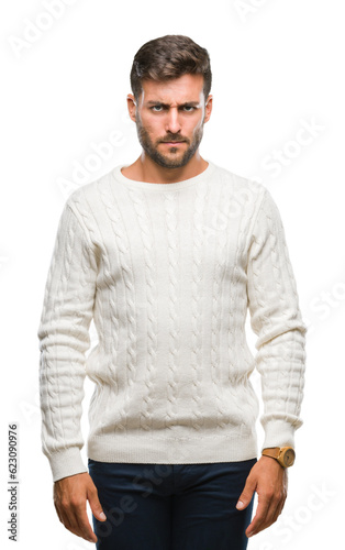 Young handsome man wearing winter sweater over isolated background skeptic and nervous, frowning upset because of problem. Negative person.