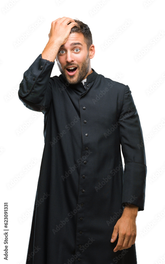 Young catholic christian priest man over isolated background surprised with hand on head for mistake, remember error. Forgot, bad memory concept.