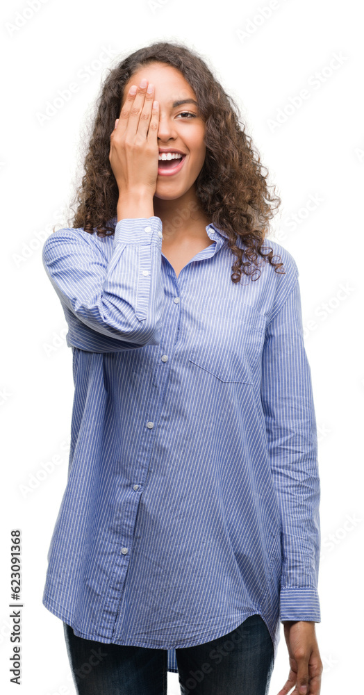 Young hispanic business woman covering one eye with hand with confident smile on face and surprise emotion. Young hispanic business woman covering one eye with hand with confident smile on face and surprise emotion.