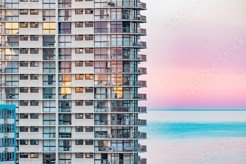 Close up section of high rise seaside apartment building with pink sunset over the beach on the Gold Coast