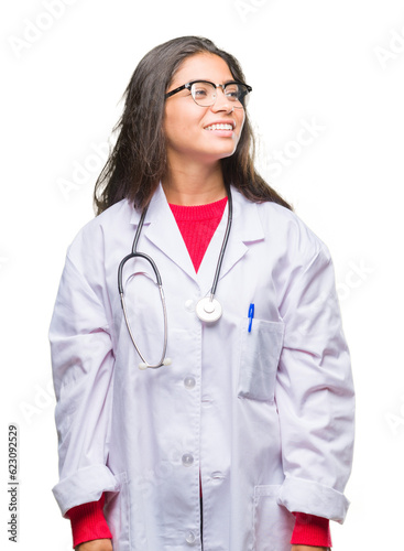 Young arab doctor woman over isolated background looking away to side with smile on face, natural expression. Laughing confident.