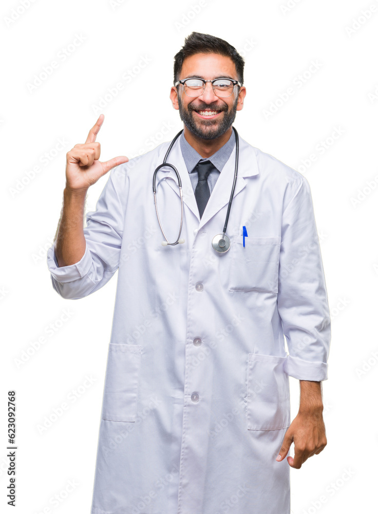 Adult hispanic doctor man over isolated background smiling and confident gesturing with hand doing size sign with fingers while looking and the camera. Measure concept. Adult hispanic doctor man over isolated background smiling and confident gesturing with hand doing size sign with fingers while looking and the camera. Measure concept.