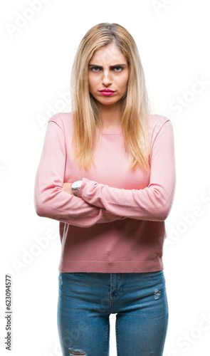 Young beautiful blonde woman wearing pink winter sweater over isolated background skeptic and nervous, disapproving expression on face with crossed arms. Negative person.
