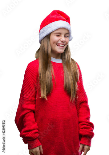Young beautiful girl wearing christmas hat over isolated background winking looking at the camera with sexy expression  cheerful and happy face.