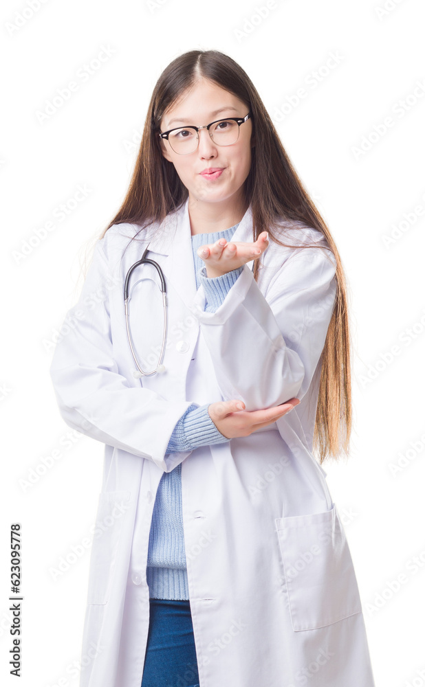 Young Chinese doctor woman over isolated background looking at the camera blowing a kiss with hand on air being lovely and sexy. Love expression. Young Chinese doctor woman over isolated background looking at the camera blowing a kiss with hand on air being lovely and sexy. Love expression.
