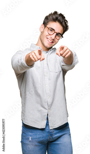 Young handsome man wearing glasses over isolated background Pointing to you and the camera with fingers, smiling positive and cheerful
