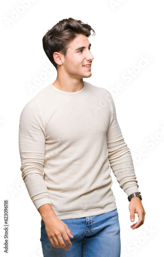 Young handsome man over isolated background looking away to side with smile on face, natural expression. Laughing confident.