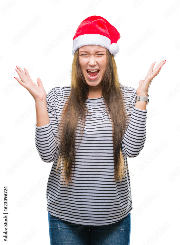 Young beautiful caucasian woman wearing christmas hat over isolated background celebrating mad and crazy for success with arms raised and closed eyes screaming excited. Winner concept Young beautiful caucasian woman wearing christmas hat over isolated background celebrating mad and crazy for success with arms raised and closed eyes screaming excited. Winner concept