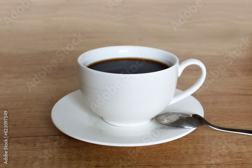 White cup of coffee on a wooden table.