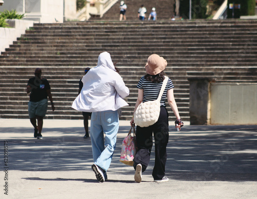 Photography Chinese tourists navigate Barcelona's streets, shielding themselves from the int
