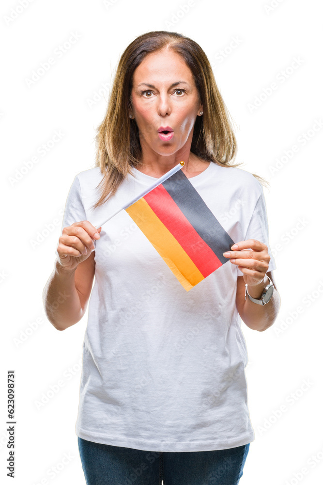Middle age hispanic woman holding flag of Germany over isolated background scared in shock with a surprise face, afraid and excited with fear expression Middle age hispanic woman holding flag of Germany over isolated background scared in shock with a surprise face, afraid and excited with fear expression