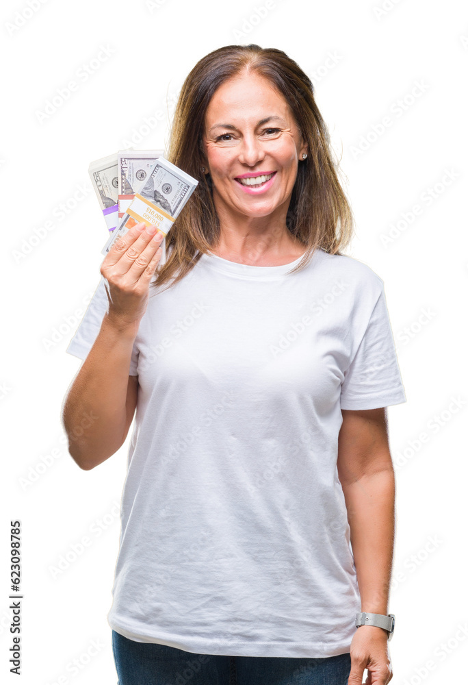 Middle age hispanic woman holding bunch of dollars over isolated background with a happy face standing and smiling with a confident smile showing teeth Middle age hispanic woman holding bunch of dollars over isolated background with a happy face standing and smiling with a confident smile showing teeth
