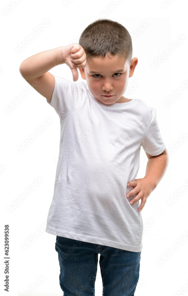 Dark haired little child with angry face, negative sign showing dislike with thumbs down, rejection concept Dark haired little child with angry face, negative sign showing dislike with thumbs down, rejection concept