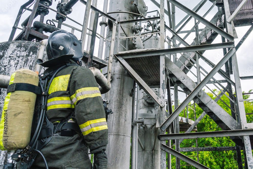 A lifeguard in a helmet and protective clothing at the factory. A firefighter in protective clothing and breathing apparatus after extinguishing a fire at a petrochemical plant. Extinguishing fires. A lifeguard in a helmet and protective clothing at the factory. A firefighter in protective clothing and breathing apparatus after extinguishing a fire at a petrochemical plant. Extinguishing fires.