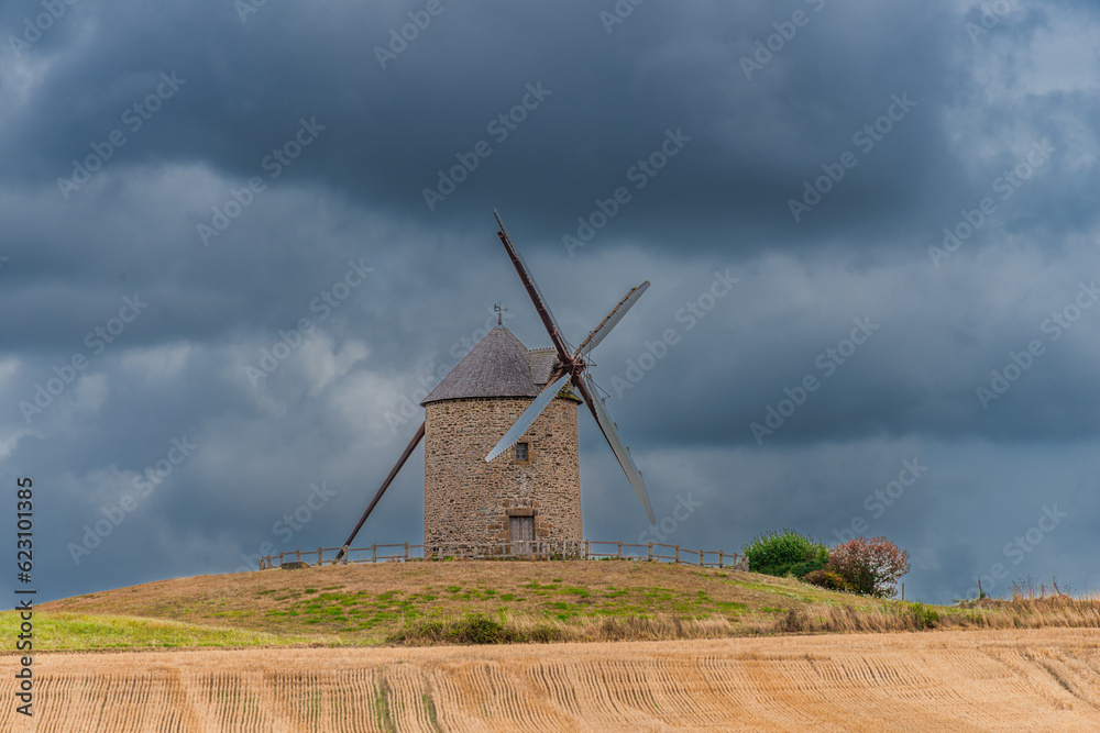 view of old rustic historic windmill Moulin de Moidrey in green grass field meadow Pontorson Normandy France view of old rustic historic windmill Moulin de Moidrey in green grass field meadow Pontorson Normandy France