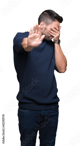 Young handsome man wearing sweater over isolated background covering eyes with hands and doing stop gesture with sad and fear expression. Embarrassed and negative concept.