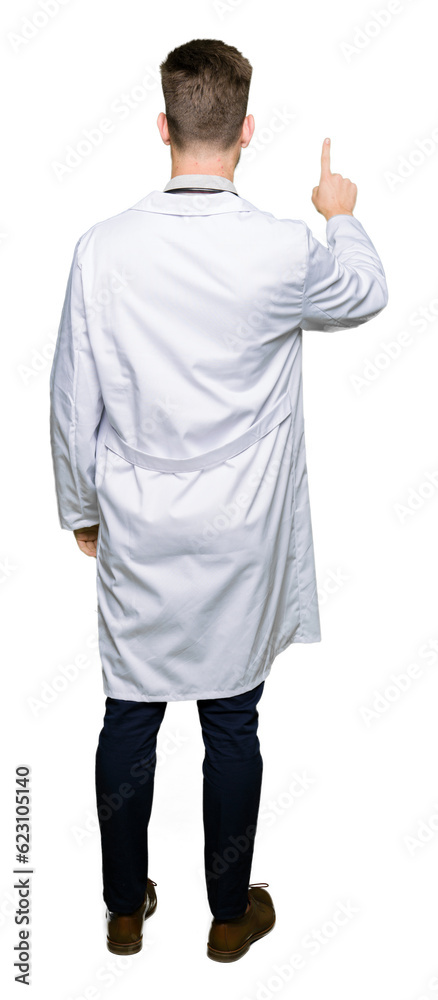 Young handsome doctor man wearing medical coat Posing backwards pointing behind with finger hand Young handsome doctor man wearing medical coat Posing backwards pointing behind with finger hand