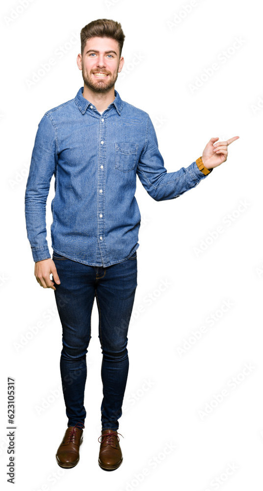 Young handsome blond man wearing casual denim shirt with a big smile on face, pointing with hand and finger to the side looking at the camera. Young handsome blond man wearing casual denim shirt with a big smile on face, pointing with hand and finger to the side looking at the camera.
