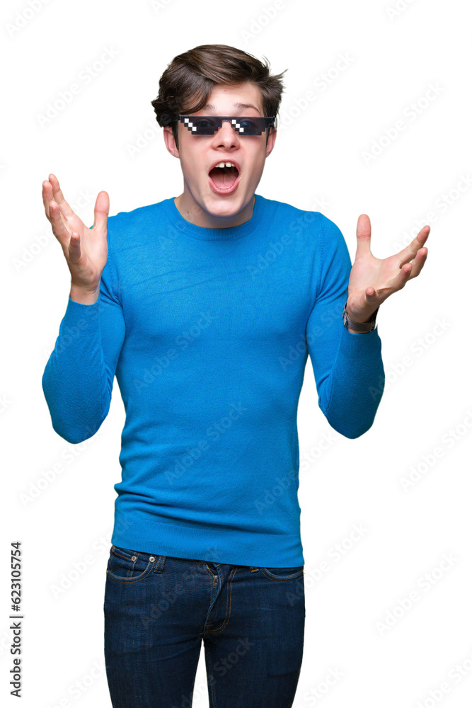 Young man wearing funny thug life glasses over isolated background celebrating crazy and amazed for success with arms raised and open eyes screaming excited. Winner concept Young man wearing funny thug life glasses over isolated background celebrating crazy and amazed for success with arms raised and open eyes screaming excited. Winner concept