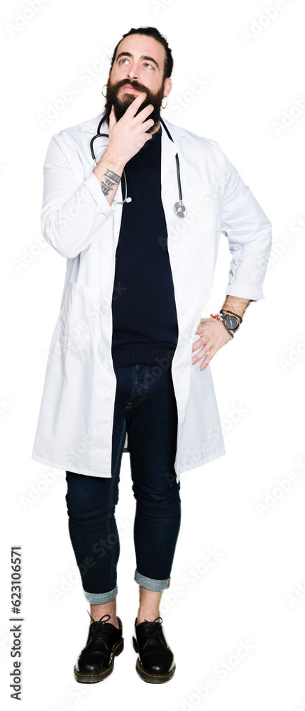 Doctor with long hair wearing medical coat and stethoscope with hand on chin thinking about question, pensive expression. Smiling with thoughtful face. Doubt concept. Doctor with long hair wearing medical coat and stethoscope with hand on chin thinking about question, pensive expression. Smiling with thoughtful face. Doubt concept.
