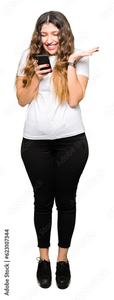 Fototapeta premium Young adult woman using smartphone very happy and excited, winner expression celebrating victory screaming with big smile and raised hands