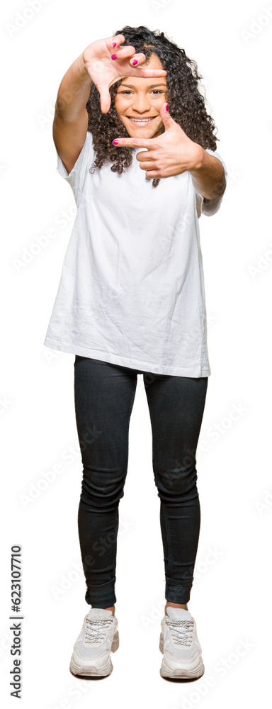Fototapeta premium Young beautiful woman with curly hair wearing white t-shirt smiling making frame with hands and fingers with happy face. Creativity and photography concept.