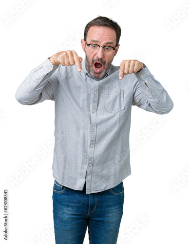 Handsome middle age elegant senior man wearing glasses over isolated background Pointing down with fingers showing advertisement, surprised face and open mouth