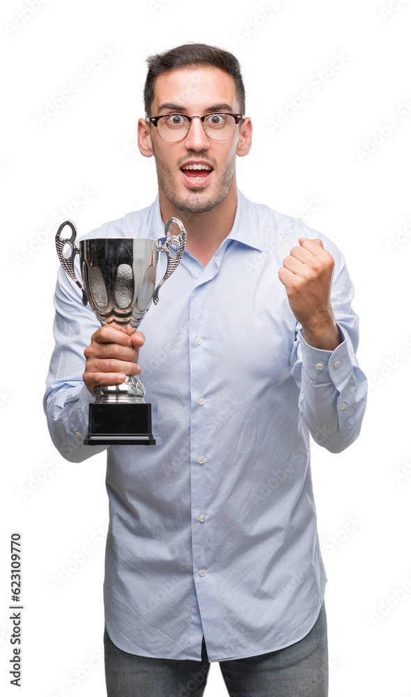 Handsome young man holding trophy screaming proud and celebrating victory and success very excited, cheering emotion Handsome young man holding trophy screaming proud and celebrating victory and success very excited, cheering emotion