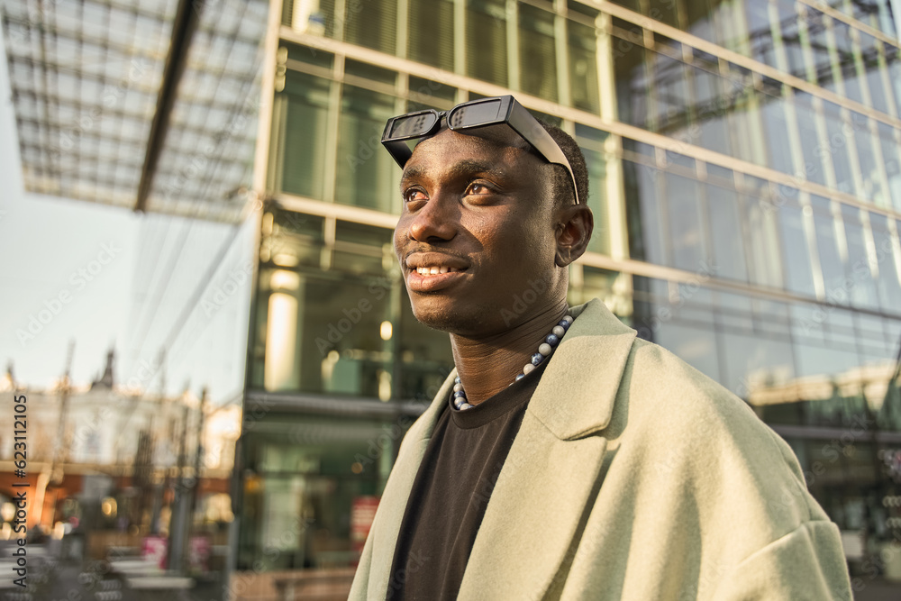 Street portrait of young man in trendy clothes looking away with wide smile Street portrait of young man in trendy clothes looking away with wide smile