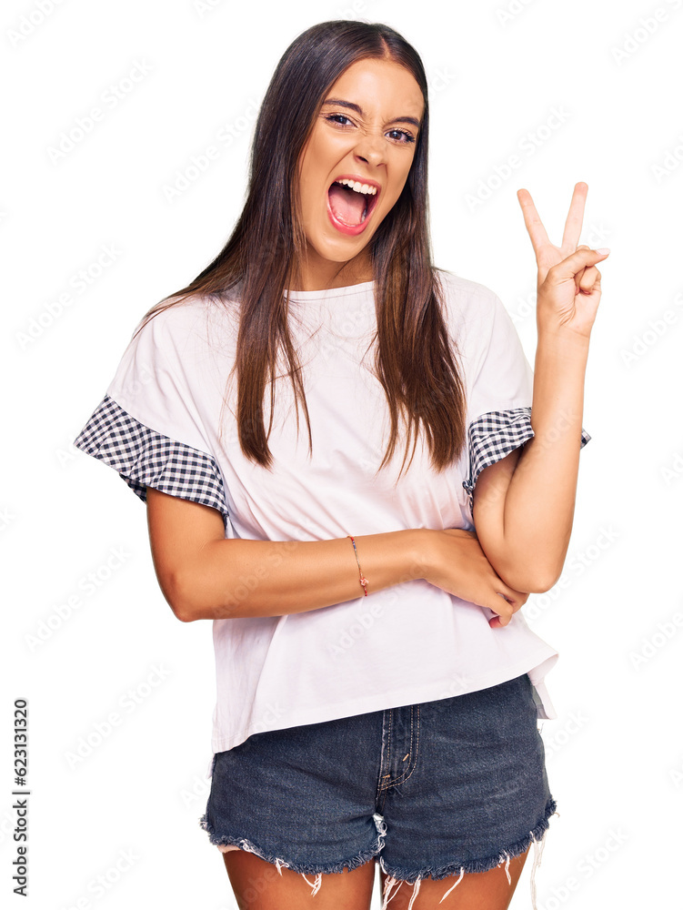Φωτογραφία Young hispanic woman wearing casual clothes smiling with happy face winking at the camera doing victory sign
